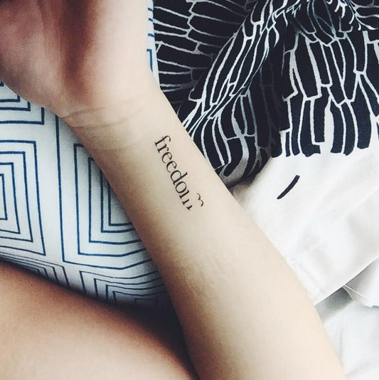 fake small freedom quote with bird lettering temporary tattoo sticker design idea on wrist